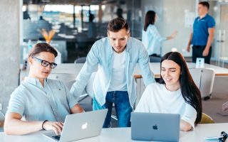 Team di un’azienda al lavoro ai portatili: gli agenti AI di Agentity affiancano le persone nelle mansioni quotidiane