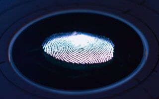 Impronta digitale illuminata su un lettore biometrico: il login senza password con le passkey